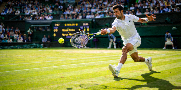 温布尔登网球锦标赛草地赛场，选手优雅击球